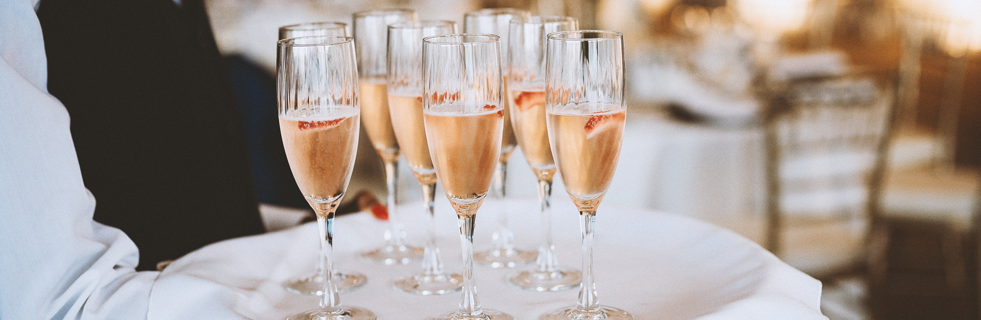 Server carrying champagne glasses on a tray.